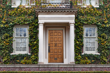 front door of large vine covered house in fall