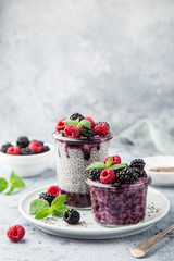 chia seeds pudding with berry sauce and fresh raspberry and blackberry in glass