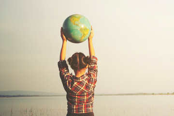 Girl holding globe with nature background