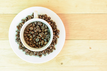 Coffee bean in the cup on wood plate