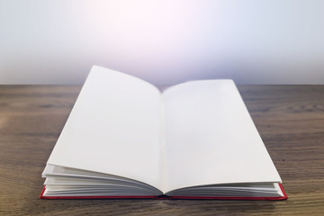 Closeup the book at wood desk with open book in class room background.
