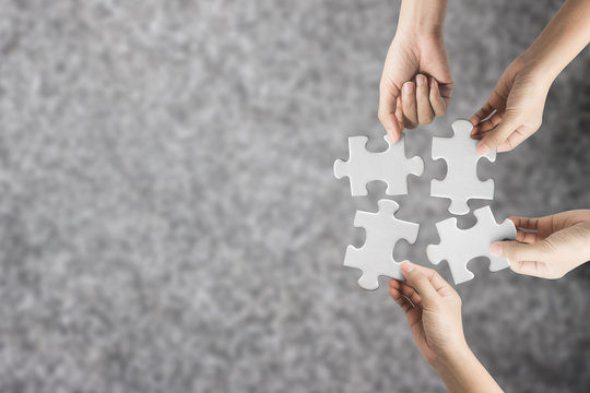 Hand holding jigsaw puzzle, team worke concept.