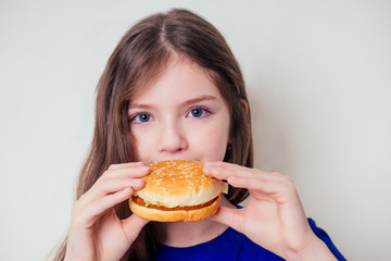 beautiful teenager girl is eating baked vegetarian burger with vegetables. Child vegan idea healthy eating concept.clear skin perfect teen acne refusal from junk food