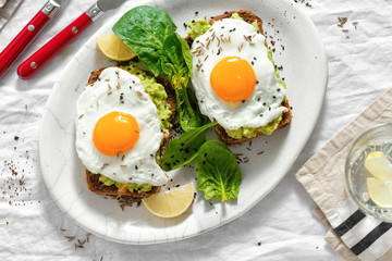 Top view healthy avocado toasts breakfast lunch fried eggs white background lemon water