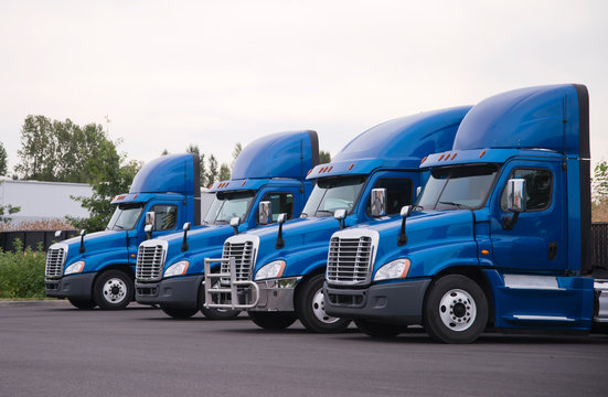 Blue Day Cab Big Rig Semi Truck For Local Delivery Stand In Row On The Parking Lot