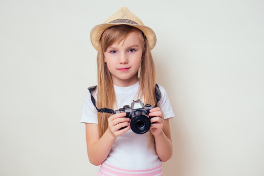 portrait of a little girl with a camera.Image of cute girl in a straw hat tourist photographer
