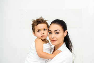 Close up of mother holding toddler son on white