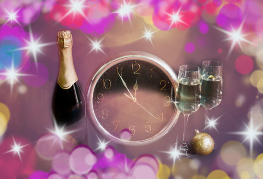 Two glasses of champagne, bottle of  champagne and clock on holiday background