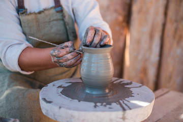 Potter is creating earthenware on potter's wheel.