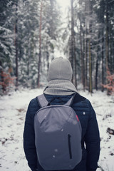 Fototapeta na wymiar Winter tourism. traveler with a backpack in the winter forest. Winter trip. Man on a winter forest road