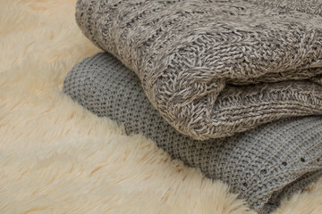 Fototapeta na wymiar two gray sweaters in the room lie on a blanket