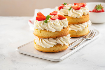 Obraz na płótnie Canvas Strawberry cake with vanilla cream on white background. Copy space.