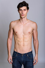 Fototapeta premium Studio shot of young handsome Brazilian man standing shirtless