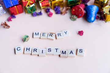 merry christmas word on wooden block with colourful christmas gift boxes in background, for banner