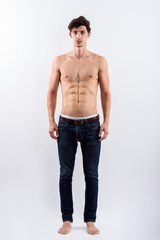 Fototapeta premium Full body shot of young handsome man standing shirtless
