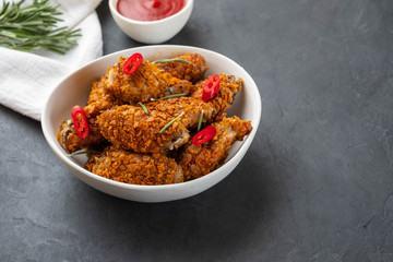 Chicken nuggets with sauce and pepper on a dark background. Copy space.