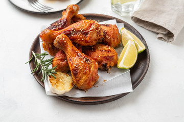 Chicken legs with sauce, rosemary and lime on a white background. Copy space.
