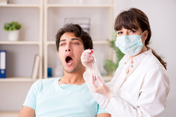 Young handsome man visiting female doctor dentist for removal of