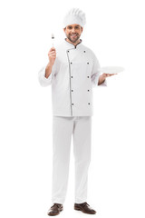 happy young chef with plate and fork looking at camera isolated on white