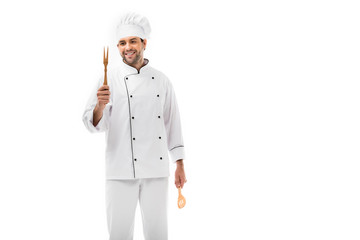smiling young chef holding wooden kitchen utensils isolated on white