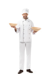 smiling young chef holding bowls isolated on white