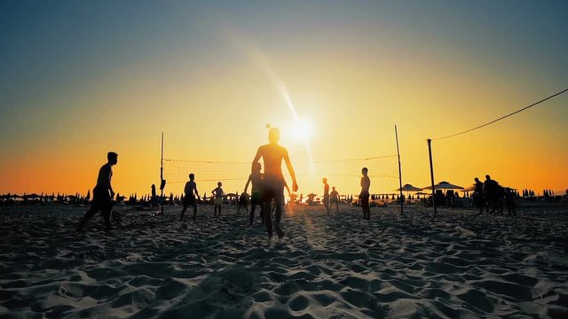 Silhouette Volleyball players play on beach at sunset in Durres, Albania