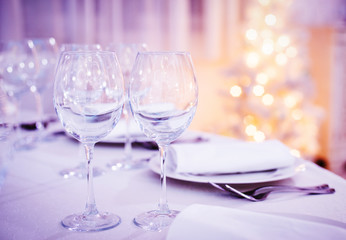 Beautiful Christmas table set. Wine glasses on celebration party
