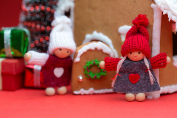 Cookie house with dolls and christmas tree on red background