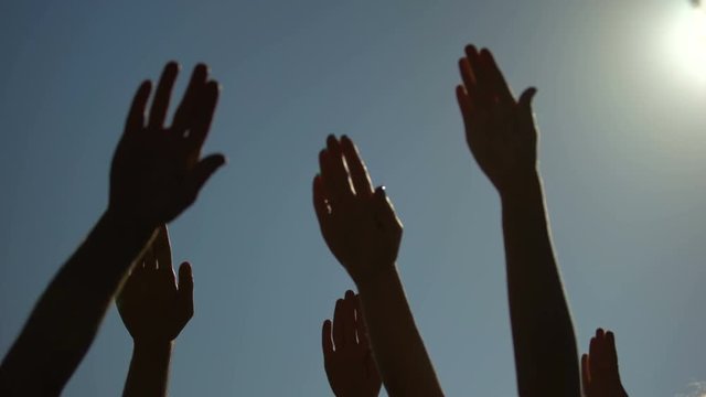 Group of people raising hands, voting outdoors, social community, speech