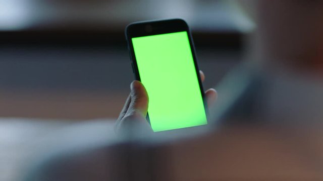 woman using smartphone watching green screen on mobile phone browsing chroma key online enjoying reading social media at home close up hands