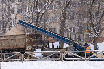 Wheel loader machine removing snow in winter .