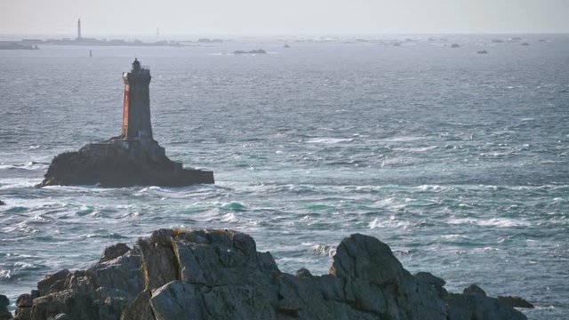 Point du Raz in Brittany, France. Windy day with seagull standing on rocks and watching the ocean's waves in October 2018.