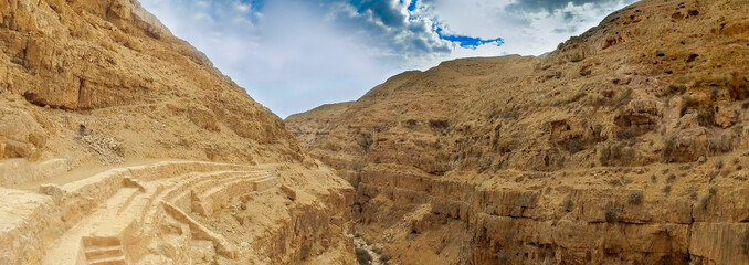 Wall of Kidron river strata canyon precipice. Panorama viewed from terrace of The Great Lavra of...