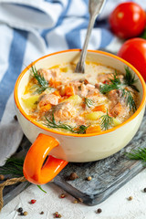 Creamy soup with salmon and vegetables in a bowl..