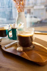 Morning cup of delicious flavored Americano on a wooden table near the panoramic window