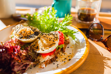 Breakfast poached eggs on toasts with cheese and grilled vegetables.