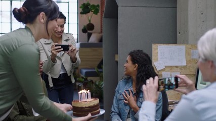happy business people celebrating birthday party excited colleague blowing candles enjoying surprise office team cheering together in diverse workplace celebration