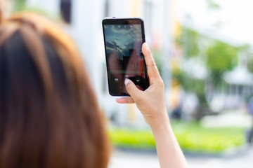 Asian woman shooting view of landscape with mobile phone