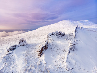 Aerial drone view winter mountains forest and road.