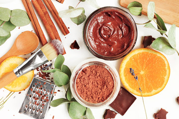 Ingredients for organic plantbased homemade skin care mask. Chocolate, orange,herbs, beauty benefits. Viewed above cosmetic mix home spa.