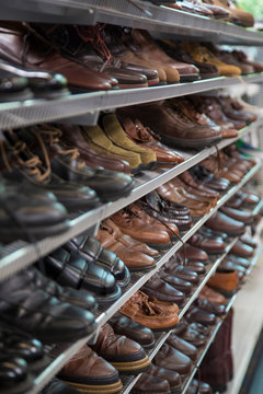 Isolated Vertical Perspective of Neutral Colored  Shoes and Boots on Thrift Store Shelves