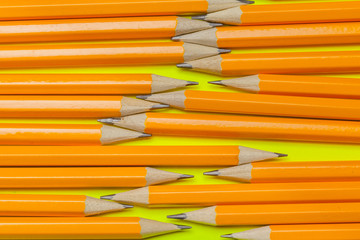 Colorful pencils on a bright green paper background