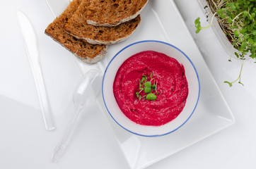 beet hummus in portions served with whole grain bread