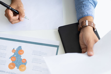 Closeup of marketing expert working with documents. Person working with diagram at desk. Marketing concept. Cropped view.