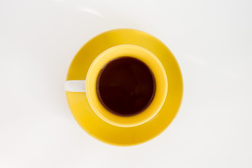 some coffee (espresso) in yellow cup on the yellow saucer on top isolated