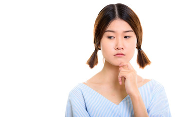 Fototapeta premium Studio shot of young beautiful Asian woman thinking while lookin