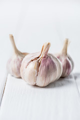 ripe garlic heads on white rustic table