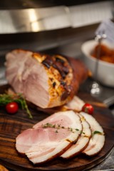 Baked Ham with Glaze on cutting board ready for sale at store. An impressive centerpiece for party, Easter, Thanksgiving, Christmas and New Year celebration. Festive holiday and season greeting.