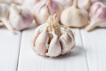 Ripe garlic bulb with cloves on white rustic table