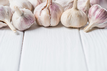 Ripe garlic heads on white rustic cook table
